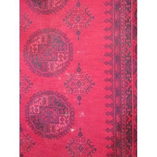 1542 - An Afghan wool carpet, three rows of central guls, multiple borders, 366cm x 275cm