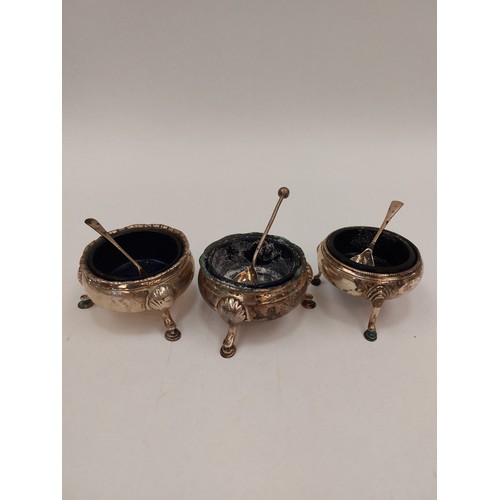 1303 - Three Georgian silver table salts, each with Bristol blue glass liners, shell relief hoof feet, with... 