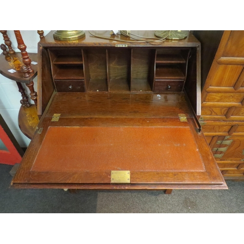 1039 - A 20th Century oak bureau, drop flap over three drawers to stretcher base, 103cm high x 78cm wide x ... 