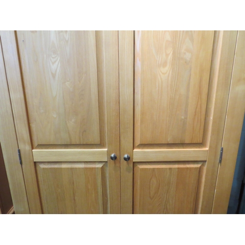 1057 - A natural oak two door wardrobe, 200cm high x 118cm wide x 64cm deep