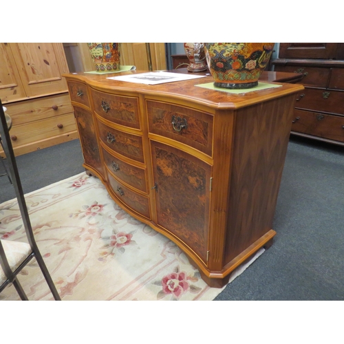 1089 - A Georgian style serpentine front burr walnut sideboard with two door cupboard and six drawers (with... 