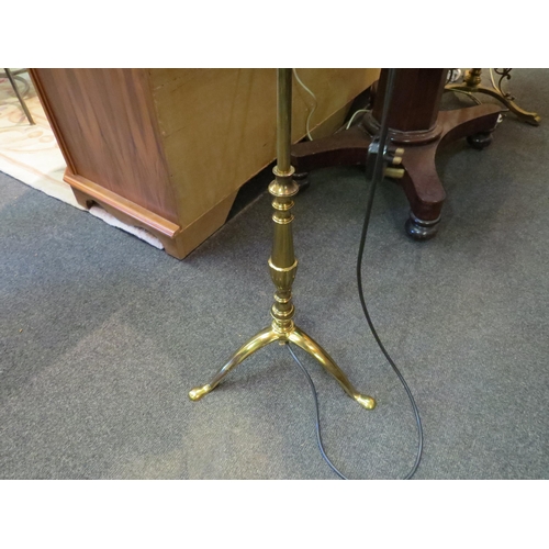 1092A - A brass twin arm standard lamp on tripod feet with shade