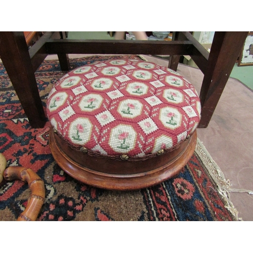 4013 - A mid Victorian walnut circular foot stool, the needlepoint seat over three turned feet    (R) £15