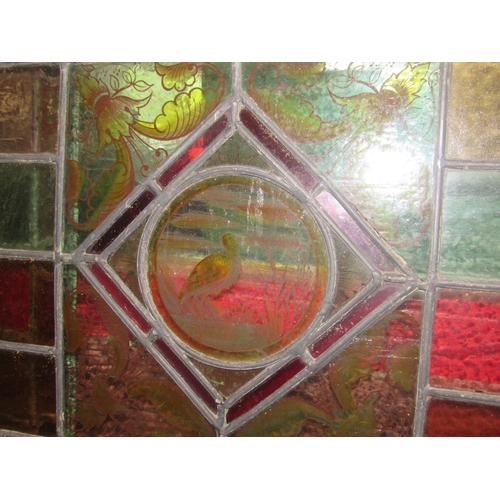 4015 - A pair of leaded/stained glass windows each 64cm x 46cm with avian/foliate decoration, a/f