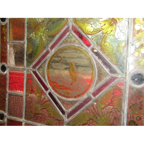 4015 - A pair of leaded/stained glass windows each 64cm x 46cm with avian/foliate decoration, a/f