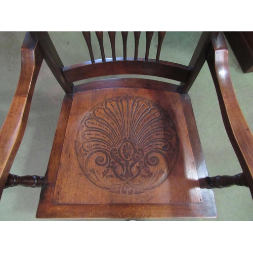 4020 - A circa 1900 oak and ash armchair with carved and turned spindle backrest the scroll end arms on tur... 