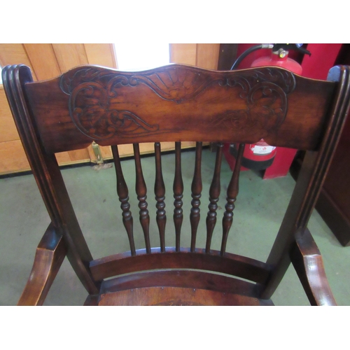 4020 - A circa 1900 oak and ash armchair with carved and turned spindle backrest the scroll end arms on tur... 