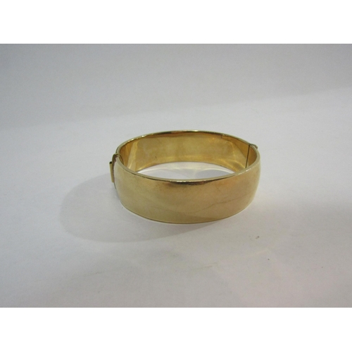 4299 - A 9ct gold metal core bangle with engraved foliate and floral detail