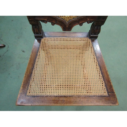 4061 - A walnut hall chair carved in Carolean style pierced with fretwork panel to front, cane work seat pa... 