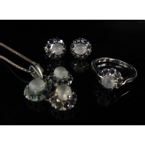 6133 - A suite of moonstone and sapphire jewellery comprising of a pair of earrings, pendant on chain and a... 