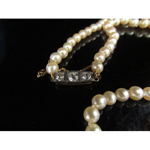 6179 - A single strand of cultured pearls, with unmarked yellow clasp set with three diamonds, 0.70ct total... 