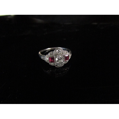 6181 - An Edwardian ruby and diamond ring, the central diamond 0.20ct approx flanked by square cut rubies a... 