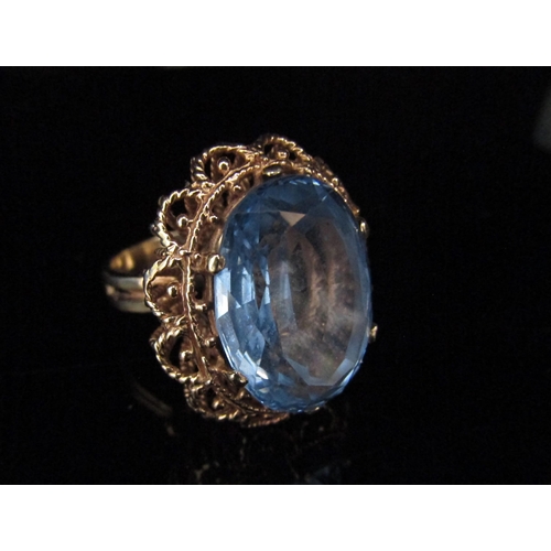 6192 - A 9ct gold ring with a large oval blue stone in high open basket mount. Size Q/R, 12.5g