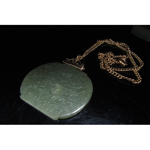 6194 - A large jade pendant with script, 5cm x 6cm hung on an unmarked gold chain, 46cm long, 7.4g