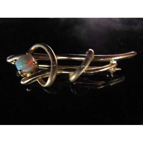 6198 - A gold brooch with an oval opal in free form setting studded with diamonds, stamped 585, 6.6g with o... 