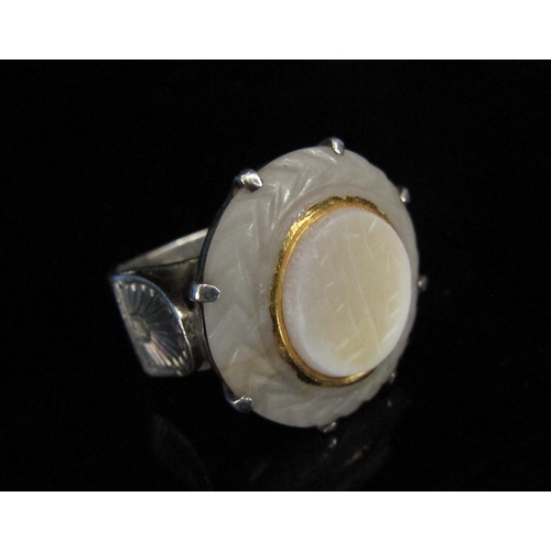 6202 - A carved white jade ring in claw setting, in a heavy white metal shank. Size N