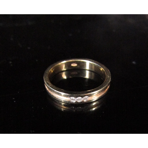 6219 - A gold band set with three small diamonds, stamped 750. Size L/M, 3.7g