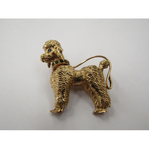 6230 - A gold brooch as a poodle with sapphire set eyes and green studded collar, stamped 14k, 14.5g