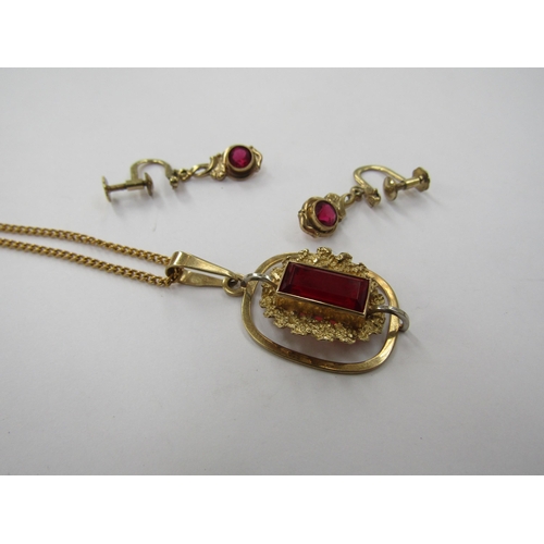 6231 - A 9ct gold pendant with dark red stone in textured mount, hung on a gold chain stamped 9ct, 6.3g and... 