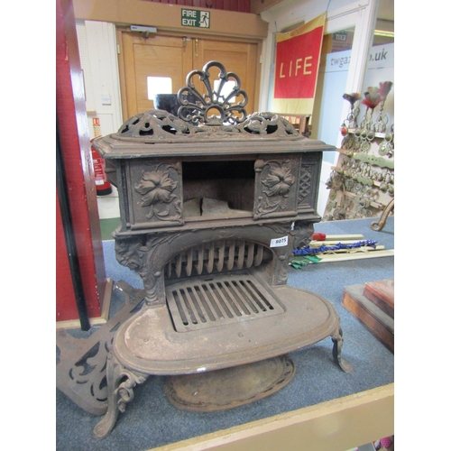 8075 - A decorative cast iron three footed 'Queenie' stove and associated trivet