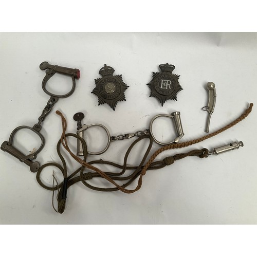 5126 - Two pairs of vintage handcuffs, a boson’s whistle, two helmet plates etc