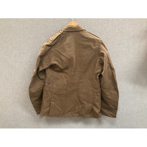 5263 - A WWI British army jacket with Suffolk shoulder titles, some moth damage, with label S.D. Jackets, d... 