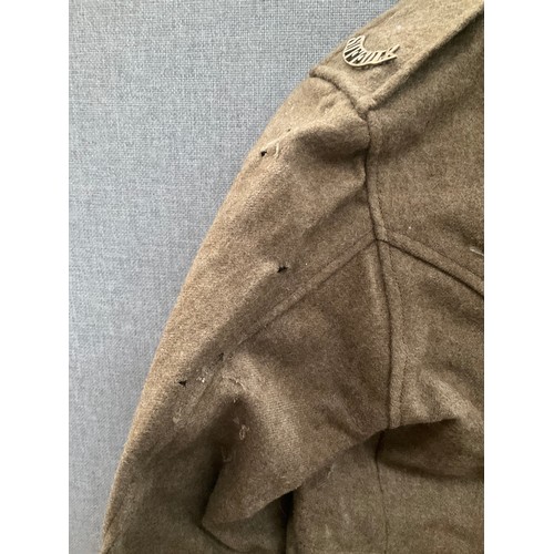 5263 - A WWI British army jacket with Suffolk shoulder titles, some moth damage, with label S.D. Jackets, d... 