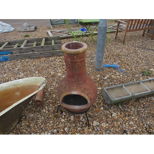 3313 - A terracotta chiminea with iron stand