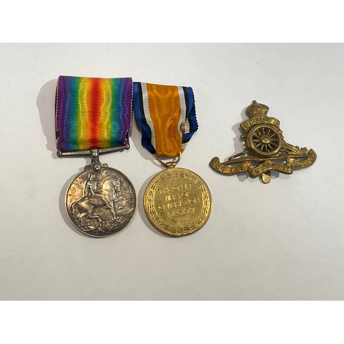 5363 - A pair of WWI medals named to 895457 GNR. A.C. HUNT. R.A., together with a George crown cap badge