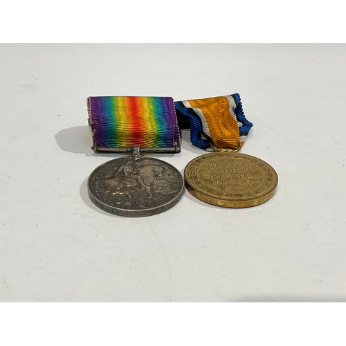 5363 - A pair of WWI medals named to 895457 GNR. A.C. HUNT. R.A., together with a George crown cap badge