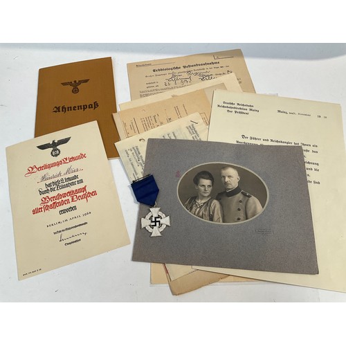 5463 - A German 25 Year Faithful Service Medal with selection of documents including award scroll and photo... 