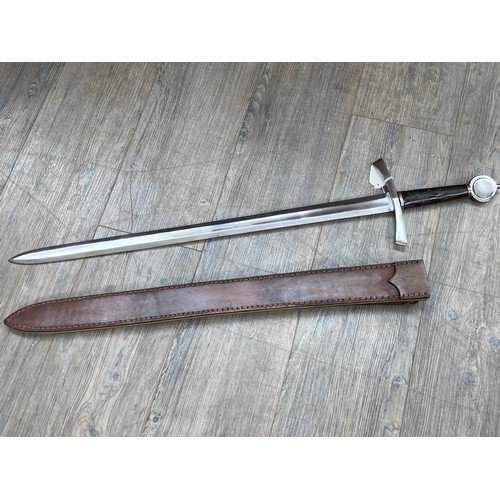 5435 - A replica of a Medieval sword with leather scabbard (with belt loop). Carbon steel blade, wooden han... 