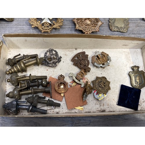 5496 - A collection of badges and insignia, horse brass and accessories including shortened swagger stick.