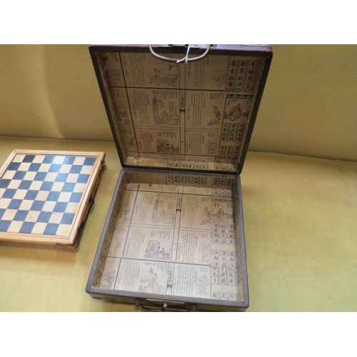 4148 - A lacquer box with Oriental design containing a miniature chess set