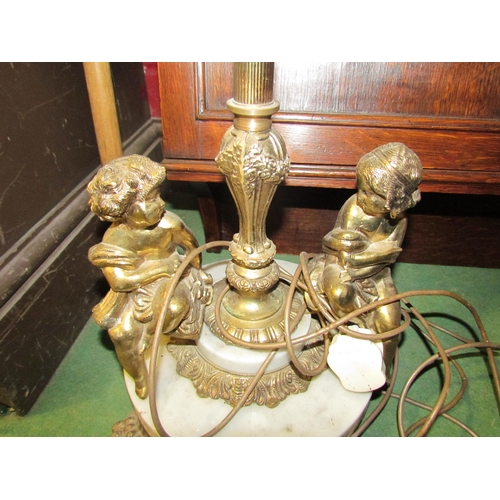 4178 - A gilt and marble column form standard lamp with seated brass figures to base on lion paw feet, 123c... 