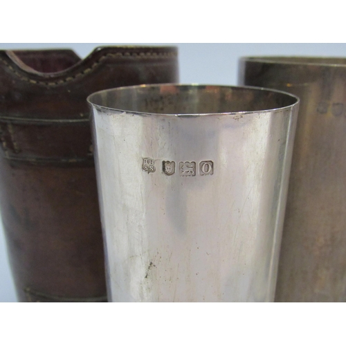 4310 - A set of three silver hunting cups in leather container, a/f