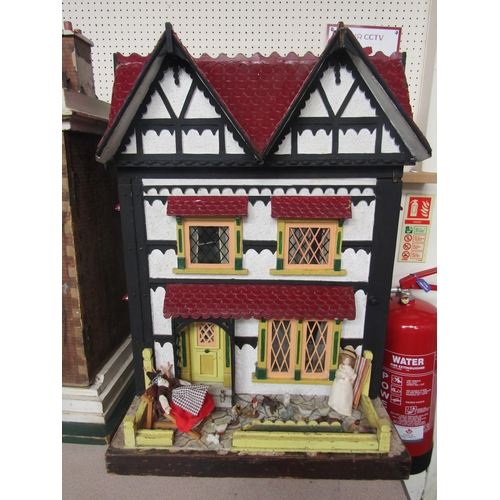 7124 - A Tudor style two storey dolls house with furniture and accessories, 81cm tall x 63cm wide x 42cm de... 