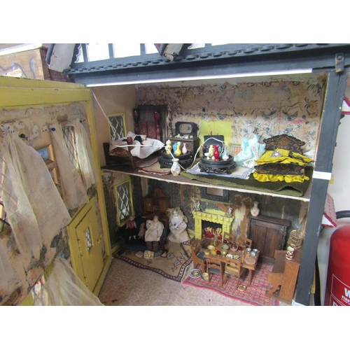 7124 - A Tudor style two storey dolls house with furniture and accessories, 81cm tall x 63cm wide x 42cm de... 