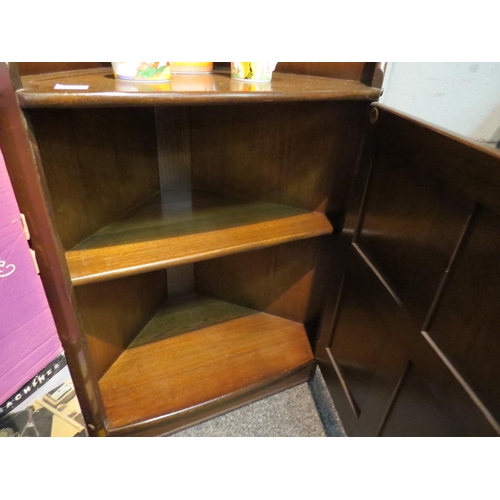 1068 - An Ercol full height corner cabinet with shelving over cupboard base, 183cm high x 75cm wide