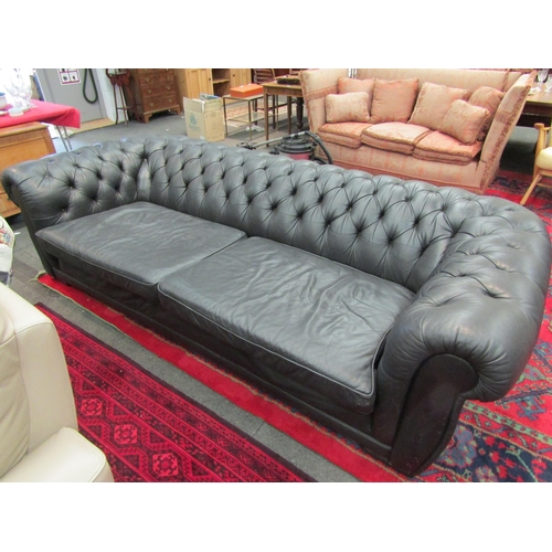 1183 - A large black leather Chesterfield sofa