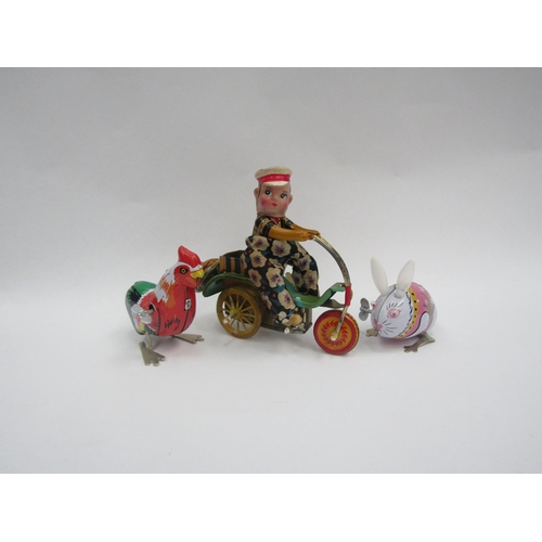 1375 - A clockwork tinplate delivery boy on bicycle, together with a tinplate Jumping Rabbit and Pecking He... 