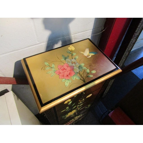 1002 - A chinoiserie lacquered six drawer floor-standing jewellery cabinet with lift top and hinged side do... 