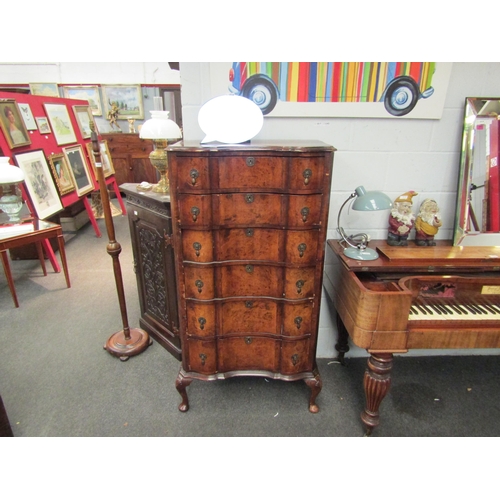 1023 - An early 20th Century mahogany and burr walnut veneered chest of six drawers with shaped front on ca... 