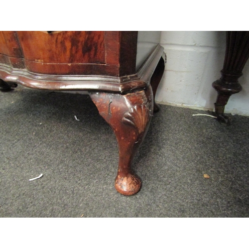 1023 - An early 20th Century mahogany and burr walnut veneered chest of six drawers with shaped front on ca... 