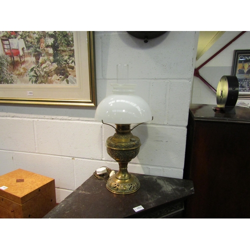 1030 - A brass oil lamp converted to electric, a/f, chip to shade