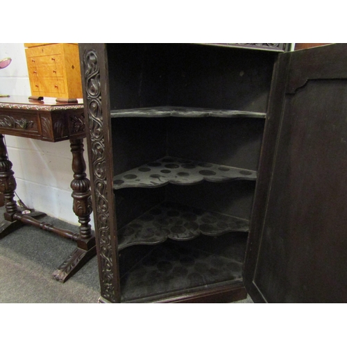 1031 - A Victorian oak corner cupboard with foliate and Tudor Rose carved door, wavy shelved interior, 111c... 