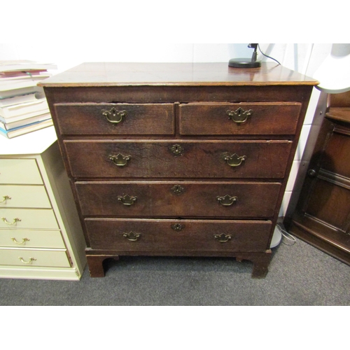 1074 - A Georgian oak country chest of two short over three long graduating drawers, brass shaped handles, ... 