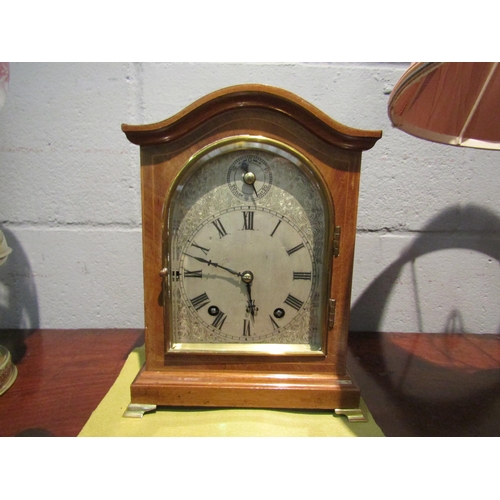 1092 - A chiming bracket clock with bevel edged glass door on brass feet, 27cm high