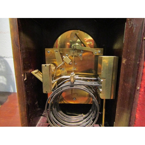 1092 - A chiming bracket clock with bevel edged glass door on brass feet, 27cm high