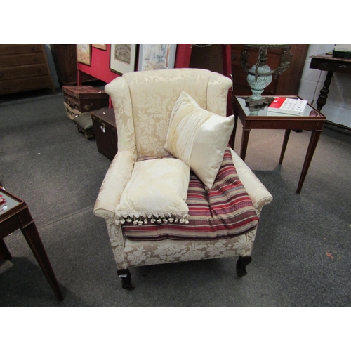 1163 - A late Edwardian wingback armchair with foliate upholstery on castors